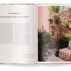 „Hacienda Los Milagros“: Zwei Seiten, linke mit Text auf Englisch und Spanisch, rechte zeigt Terrasse mit Pflanzen und Sitzbereich.