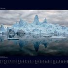 01 Januar. Ein Kalenderbild mit Eisbergen, die sich im Wasser spiegeln, unter wolkigem Himmel.