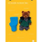 "ICH GLAUBE, DU MUSST MAL!" Auf gelbem Hintergrund sind ein blauer Toilettenstuhl und ein Teddybär in grüner Kleidung abgebildet.