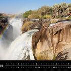 Namibia 03, Kalenderstruktur, Epupa Falls, Kaokoland. Wasserfall fließt über Felsen, ein Regenbogen erscheint im Nebel.