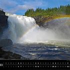 Schweden 03, Der mächtige Wasserfall Tännforsen. Ein großer Wasserfall mit Regenbogen vor einem bewaldeten Hügel.