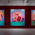 Drei Gemälde zeigen abstrakte, ineinander verschlungene Figuren auf roten und blauen Hintergründen in einem beleuchteten Raum.