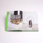 Ein geöffnetes Buch zeigt moderne Skulpturen mit architektonischen Motiven auf weißem Sockel und einem Kreisrahmen.