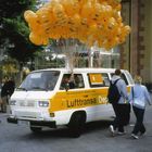 Text: "www.deportation-alliance.com" und "Lufttransa Deport". Ein Van mit vielen gelben Ballons zieht die Aufmerksamkeit auf sich.