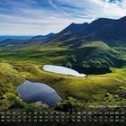 Kalendertext: "Ring of Kerry Mountains – West-Irland 4". Eine malerische Landschaft mit grünen Bergen und zwei ruhigen Seen.
