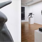 Abstrakte Skulpturen in einer Galerie, links ein flügelartiges Werk, rechts eine skulpturale Kopf-Büste, Holzfußboden.