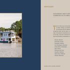 "Spotlight: Houseboat and float house communities in small towns. Branson, Brunswick, Demopolis, Fort Washington, Friday Harbor."

Ein zweistöckiges blaues Hausboot auf einem Gewässer, umgeben von Bäumen.