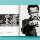 Der Text beschreibt eine Zeitschrift mit prominenten Fotos. Links zwei Männer mit Cowboyhüten, rechts ein Mann mit Schädelring.