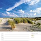 28. Woche, Juli 2027. Strand mit Dünen und blauem Himmel. Dünengras im Vordergrund, weitläufiger Himmel mit Wolkenformationen.