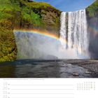 Regenbogen am Wasserfall Skógafoss, Südisland. Kalenderwoche 29, Monat Juli. Majestätischer Wasserfall mit grünem Moos.