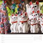 Maneki-nekos im Tempel Gotoku-ji in Tokio. Zahlreiche weiße Katzenfiguren mit erhobenen Pfoten und roten Halsbändern.