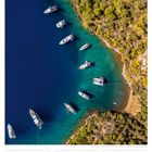 Kalenderbild: Boote in einer Bucht in Fethiye, Türkei. Oberhalb ist ein bewaldetes Ufer zu sehen, unten der Kalender von Juli/August 2027.