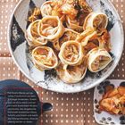 Text: "Für Kimchi-Mandu gut gereiftes Frischkimchi aus dem Kühlregal verwenden."  
Dumplings auf einem Teller mit Kimchi und Sesam.