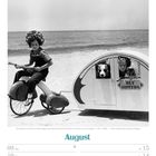 Text: "Ely Sisters", "August", "Maria Himmelfahrt", "KW32/2027". 
Kind auf Dreirad, Hund und Kind im kleinen Wohnwagen am Strand.