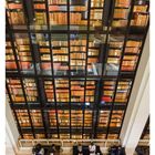 Text: "35 AUG/SEP MO 30 DI 31 MI 01 DO 02 FR 03 SA 04 SO 05." Eine Glaswand voller Bücher mit Menschen, die darunter arbeiten.