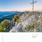 August 2027, 33. Woche. Kalenderseite mit einem Berggipfel und Kreuz in den Ammergauer Alpen bei Morgendämmerung.