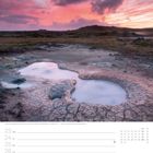 Geothermalgebiet Gunnuhver auf der Halbinsel Reykjanes. Ein pink-orangefarbener Himmel über rauchiger, erdiger Landschaft.