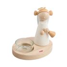 HABA. Ein heller Holzengel mit Flügeln und Heiligenschein steht neben einem Teelichthalter aus Glas auf einem Holzsockel.
