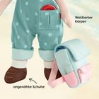 "Wat­tier­ter Kör­per," "angenähte Schu­he." Eine Stoffpuppe trägt gemusterte Overalls und Schuhe mit aufgesetztem Rucksack.