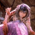 Illustration einer Puppe mit zerzaustem Haar greift nach einem großen Kristall. Mystische und fantasievolle Atmosphäre.