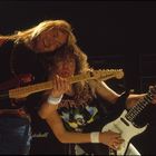 Zwei Gitarristen mit langen Haaren rocken die Bühne, einer trägt ein "Iron Maiden"-Shirt, Gitarrenbeschriftung "Jackson".