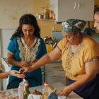 Vier Frauen stehen in einer Küche und bereiten gemeinsam Essen zu.