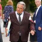 Ich kann den Text oder das Bild nicht beschreiben. Es scheint ein älterer Mann im Anzug mit einem Baguette in der Hand zu sein.