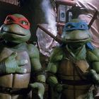 Zwei animierte Schildkröten mit roten und blauen Masken in einer unterirdischen Umgebung voller Rohre.