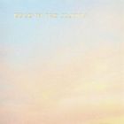 Text "HEAD IN THE CLOUDS" über einem sanften, pastellfarbenen Himmel in Blau- und Rosa-Tönen.