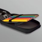 Ein Mäppchen mit mehreren bunten Buntstiften ist geöffnet, die Stifte sind ordentlich in Schlaufen eingerollt.