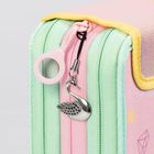 Eine Tasche mit pastellgrünen und -rosa Reißverschlüssen und einem Metallanhänger in Schwanenform.