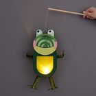 Eine Laterne in Froschform, die leuchtet. Ein Stock hält sie oben.