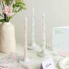 Text: "Happy Birthday", "Olivia". Drei dekorative Kerzen, Blumen in einer Vase und ein Glas auf einem Tisch.