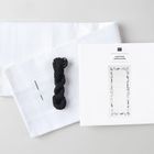 "ANLEITUNG INSTRUCTIONS" steht auf einer Verpackung. Daneben sind ein weißes Stoffstück, ein schwarzes Garn und Nadeln.