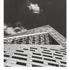 Kalender mit Zahlen 1 bis 31, darunter "08" und "DUMONT". Schwarz-weißes Foto eines modernen Gebäudes gegen wolkigen Himmel.