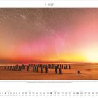 7 · 2027. Text über Nordlichter in Schleswig-Holstein. Ansicht eines Strandes mit vielen Holzpfählen, darüber ein rötlicher Himmel.