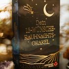 Eine Schachtel mit dem Text: "Dein 13-Wünsche-Rauhnachts-Orakel". Ein goldener Mond und Sterne schmücken das Design.