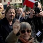 Ein Schild mit der Aufschrift "DANMARK". Personen jubeln, eine hält eine Kamera, eine andere schwenkt eine kleine Fahne.