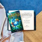 "The Last Immortals: Dawn of the Axolotl" von Kit Brooks. Buchcover mit leuchtend blauem Axolotl auf grünem Hintergrund.