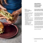 Titel: "Smashed Tofucado Toasties". Rezept für 2 Personen. Zubereitungszeit: 30 Minuten. Zutaten: Tofu, Avocados, Brot. 

Links ist ein Sandwich mit cremiger Füllung. Eine Person hält die Hälfte; die andere liegt auf einem Teller.