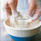 Eine Hand knetet Teig in einer blau-cremefarbenen Schüssel.