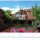 Colmar Klein Venedig. Eine malerische Brücke über einem Fluss, umrahmt von bunten Fachwerkhäusern und üppigem Grün.