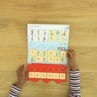 Oben steht "Heute ist Kuscheltiertag". Kind hält einen bunten Kalender mit Zahlen- und Bildkarten auf einem Holztisch.