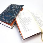 Buch mit blauem Einband und goldenen Punkten, Aufschrift "DEUTSCHE GEDICHTE". Geöffnet mit Lesebändchen.
