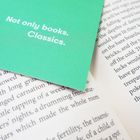 Text: "Not only books. Classics." Ein grüner Einleger liegt auf aufgeschlagenen Buchseiten mit feinem Text.