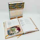 Ein Kochbuch mit dem Titel "Die österreichische Küche". Geöffnet zeigt es ein Rezept mit einem Bild von einem Gericht.