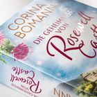 „Corina Bomann: Die Geheimnisse von Rosewell Castle“. Illustration mit Distelblüten und einem Schloss.