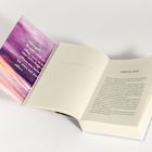 Aufgeschlagenes Buch mit violettem Cover. Zitat: „George?", „Wir", Textbeginn: „Kapitel Eins".