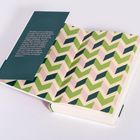 Text auf grünem Umschlag: „Es hatte auch eine Schönheit, auf dem Fluss durch die Nacht zu treiben...“; gemustertes Innenpapier in Zickzack-Muster.