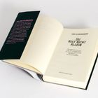 Text: "JAN FLEISCHHAUER DU BIST NICHT ALLEIN" und "»IM LAND DA DRAUSSEN". Ein aufgeschlagenes Buch mit dunklem Schutzumschlag.